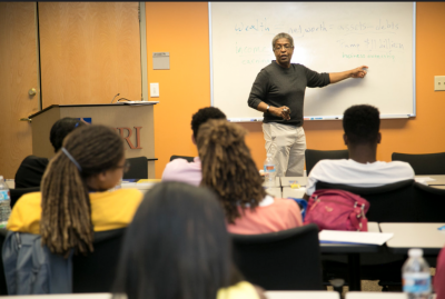 A man standing at a chalkboard teaching a class