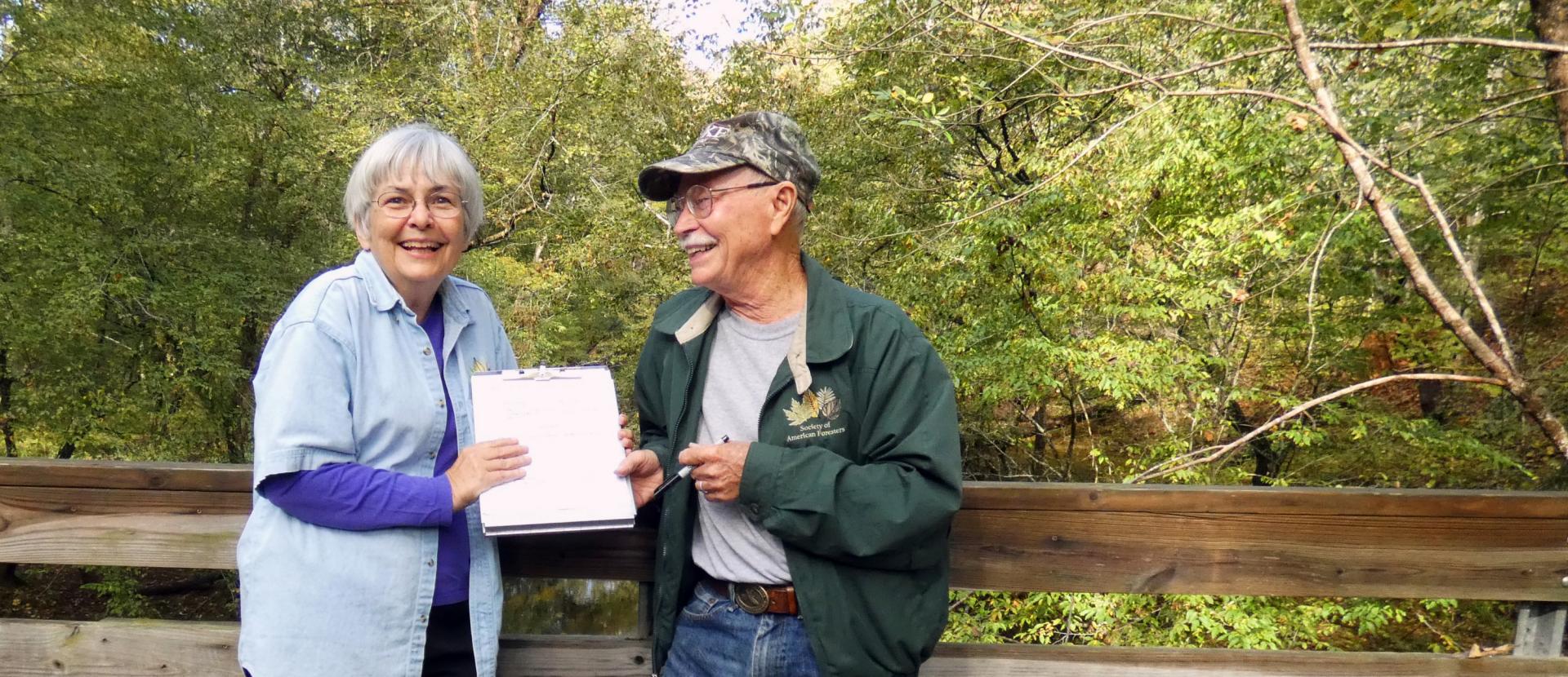 Mary and Judd Edeburn at a bridge in Duke Forest after signing their bequest intention.