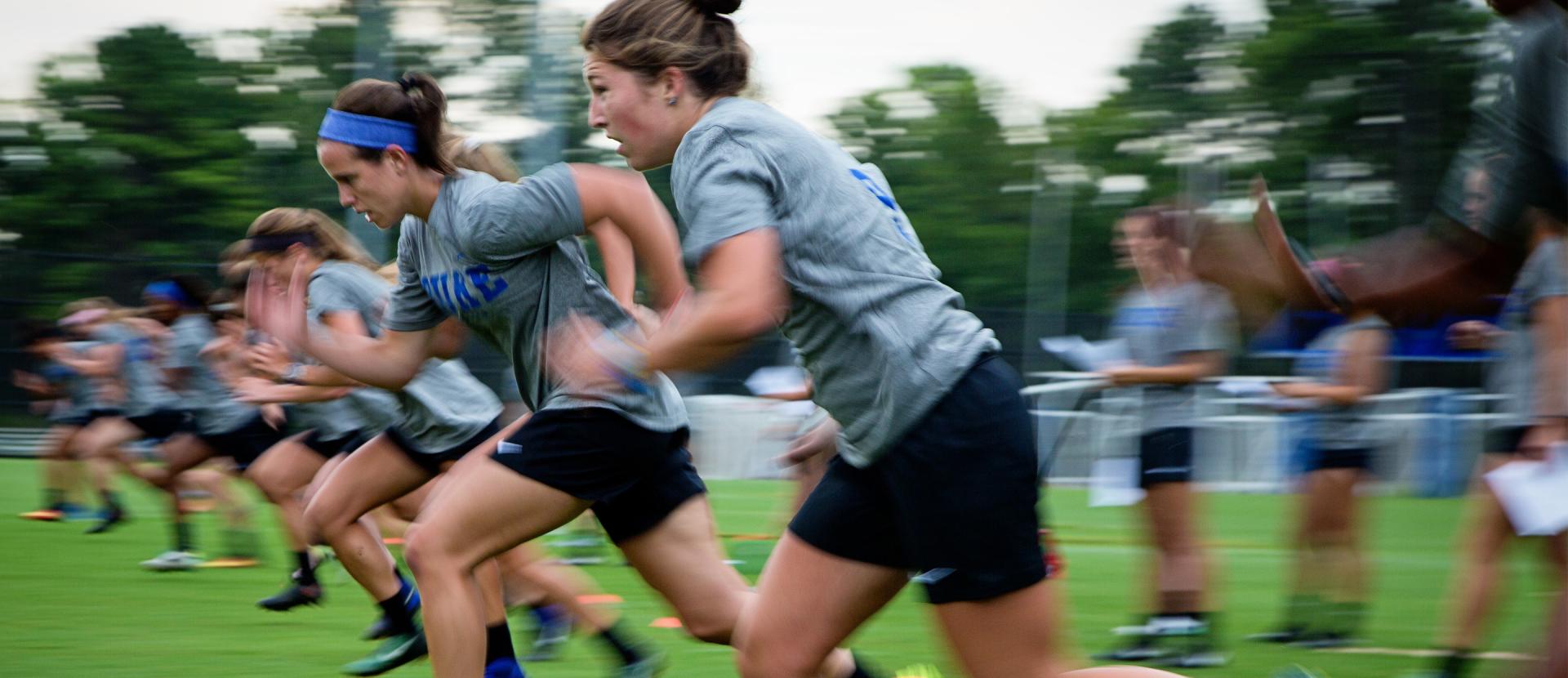 Duke women's soccer players run sprint drills in practice.