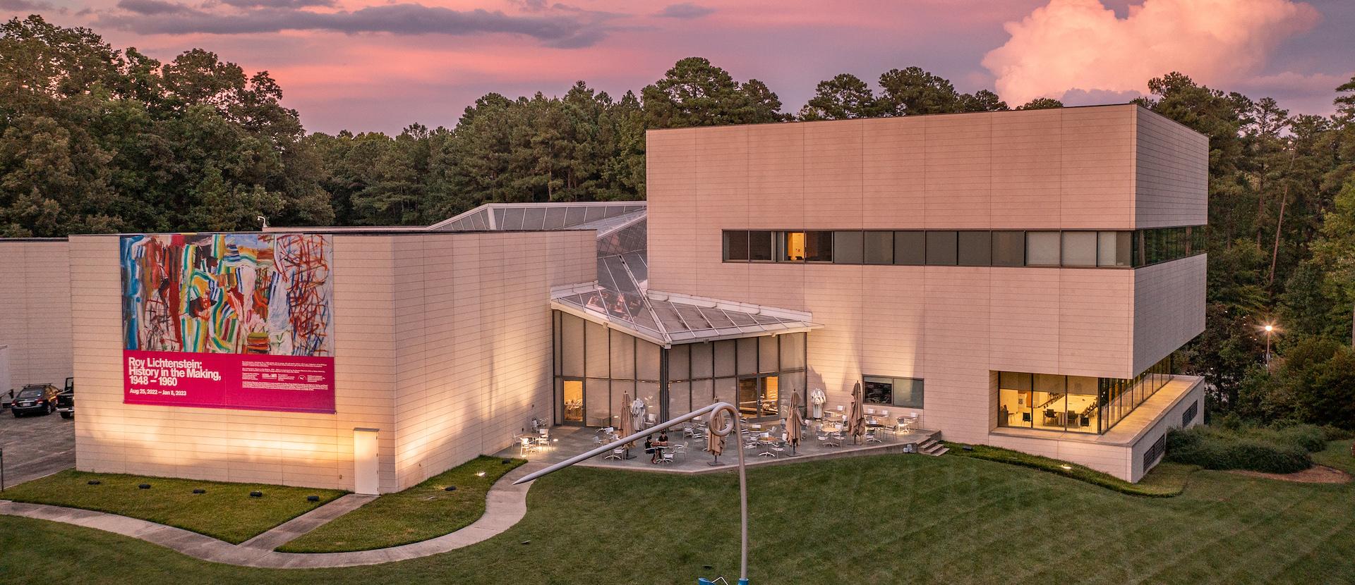 A low aerial photo of the Nasher Museum of Art with a sunset in the background.