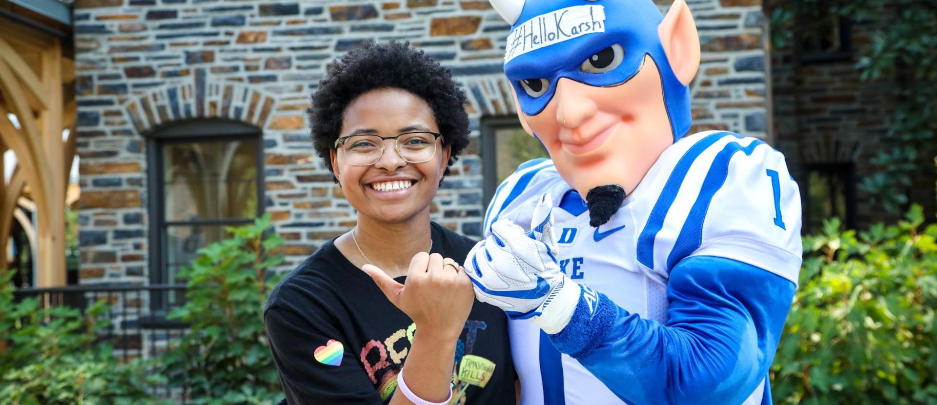 Duke student and Blue Devil mascot making the Durham Bull hand sign. 