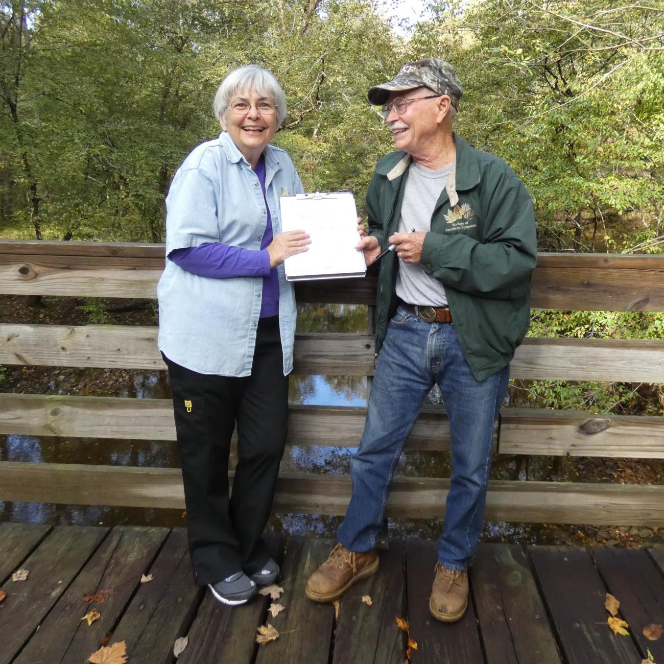 Mary and Judd Edeburn at a bridge in Duke Forest after signing their bequest intention.