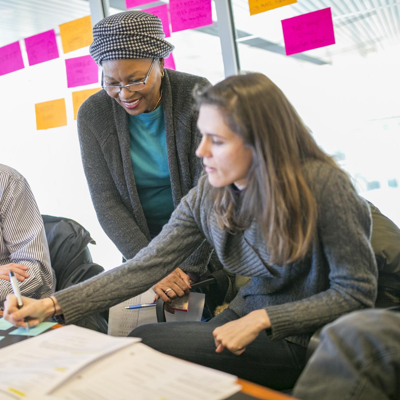 Three Individuals Collaborating in a Conference Room