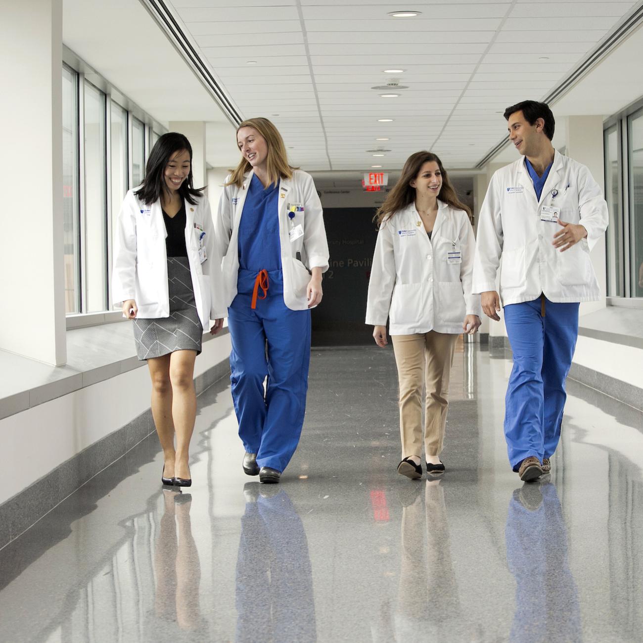 Four Duke Health caregivers walk down a hallway.