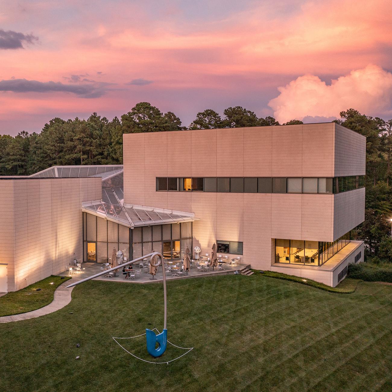 A low aerial photo of the Nasher Museum of Art with a sunset in the background.