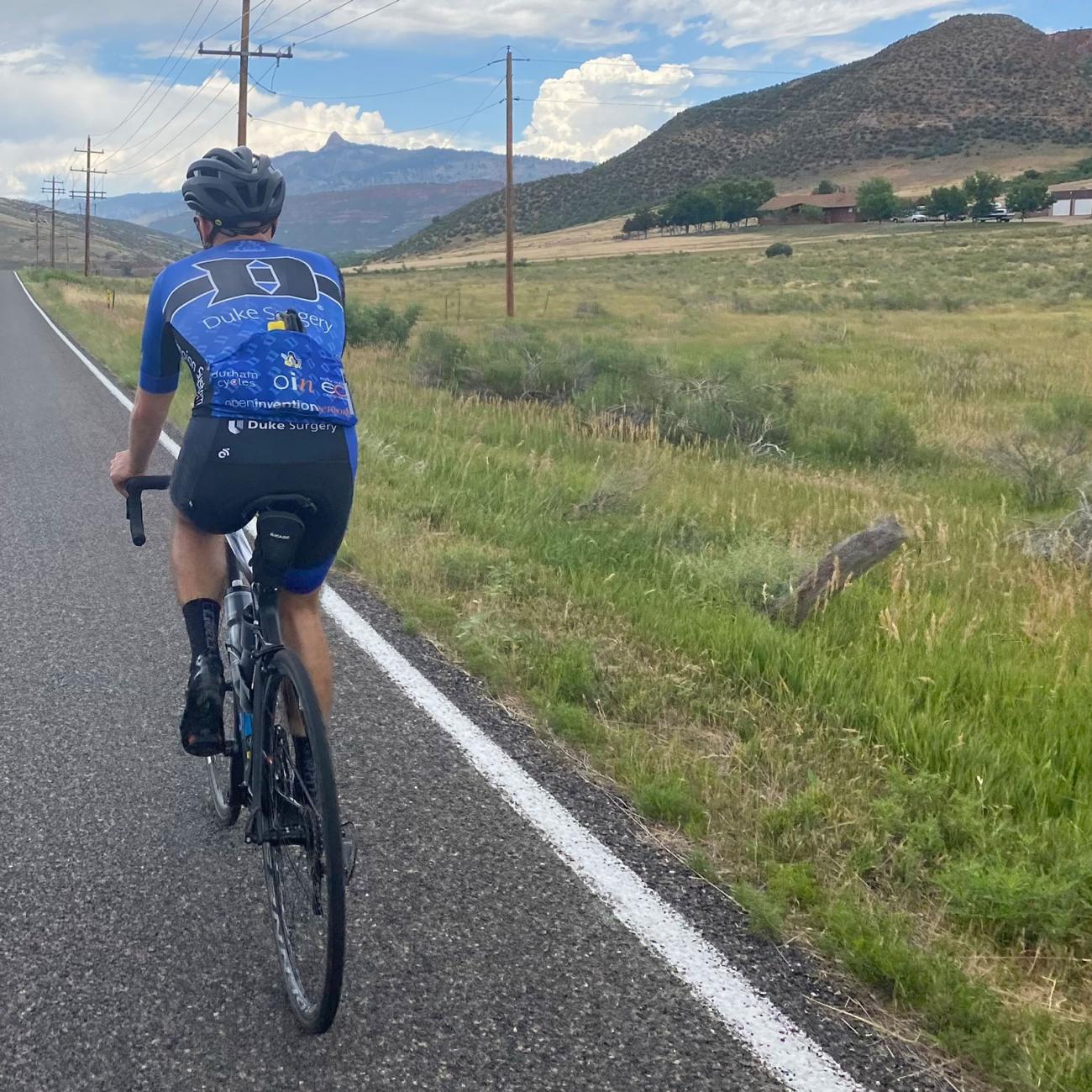 Cycling on road next to meadow