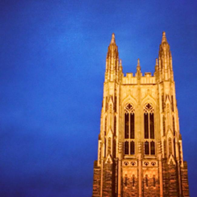 Duke Chapel illuminated against a dark blue sky