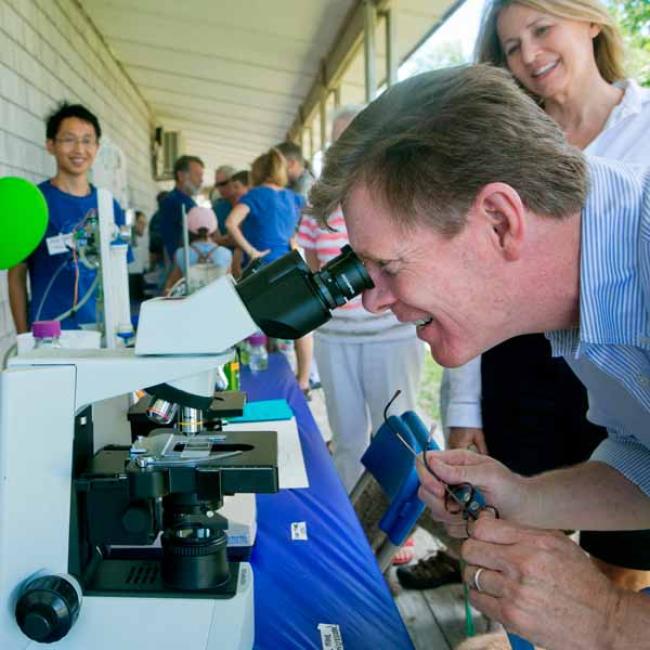 President Price looking into a microscope. 