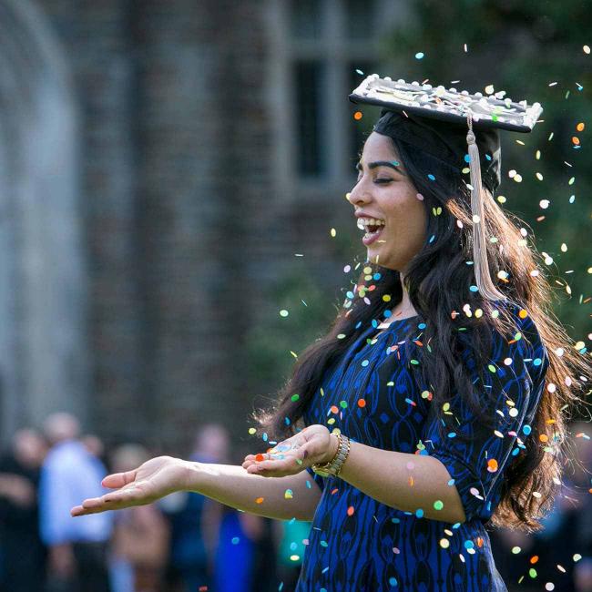 Duke student laughing with confetti. 